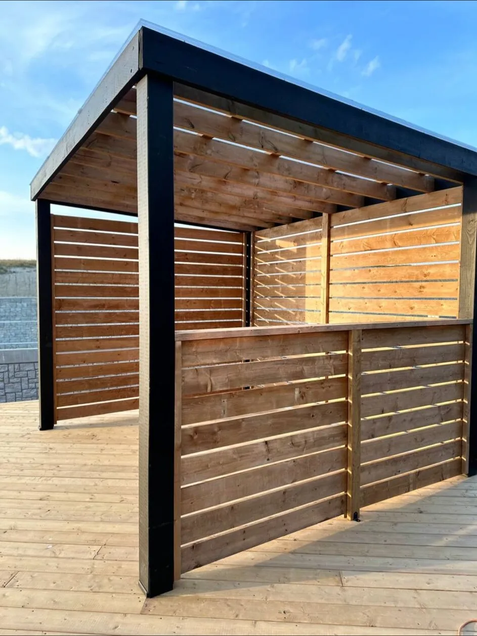 Deck with a pergola and privacy screening by Apex Exterior Works